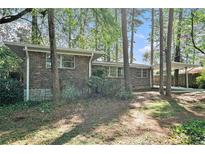 Brick home featuring a carport, situated among trees at 2480 Warwick Ne Cir, Atlanta, GA 30345