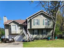 Two-story home featuring green siding, brown roof, and a staircase leading to the entrance at 126 Amberwood Ln, Euharlee, GA 30145