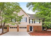 Inviting two-story townhome with brick accents, attached two-car garage, and a well-manicured front lawn at 3 S Riversong Ln, Alpharetta, GA 30022