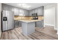 Modern kitchen features stainless steel appliances, gray cabinets, granite countertops, and hardwood floors at 3 S Riversong Ln, Alpharetta, GA 30022