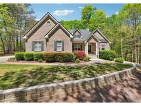 Charming brick home featuring a well-manicured lawn and mature landscaping at 45 Harvey Ave, Covington, GA 30016