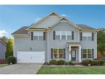 Charming two-story home with gray siding, a well-manicured lawn, and an attached two-car garage at 4528 Venus Sw Ct, Powder Springs, GA 30127