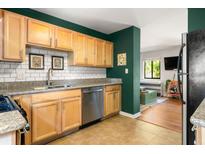 Well-lit kitchen with stainless steel appliances, granite countertops, light brown cabinetry, and a subway tile backsplash at 1355 Euclid Ne Ave # 15A, Atlanta, GA 30307