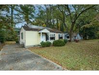 Charming one-story home with a traditional design and cozy curb appeal, surrounded by mature trees in a residential area at 3074 Delowe Dr, Atlanta, GA 30344