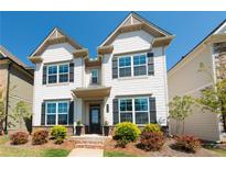 Charming two-story home with white siding, dark shutters, and a landscaped front yard at 3495 Delegate Aly, Scottdale, GA 30079