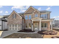 Charming brick two-story home with a two-car garage and covered entryway at 5827 Creek Indian Dr, Sugar Hill, GA 30518