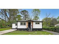 Charming renovated home with a modern black and white exterior and landscaped front yard at 2610 Knoll Se Rd, Smyrna, GA 30080