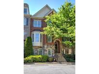 Charming brick and stone townhome with manicured landscaping and inviting entryway stairs at 636 Parkside Village Nw Way, Marietta, GA 30060