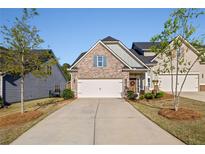 Charming home with a two-car garage, landscaped yard, and covered porch, set on a sunny day at 4565 Grenadine Cir, Acworth, GA 30101