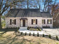 Charming brick home with a manicured front yard, black shutters, and a newly poured concrete walkway at 833 Martina Ne Dr, Atlanta, GA 30305