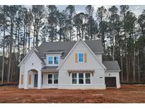 Charming new construction home with a stylish white facade, complementary shutters, and an inviting, covered front entrance at 6565 Rhett Run, Cumming, GA 30028