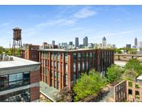 Brick apartment building with a water tower on top, showcasing city views, and mature trees under a clear blue sky at 170 Boulevard Se # E006, Atlanta, GA 30312
