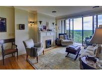 Bright living room with fireplace, hardwood floors, and large windows offering stunning views at 145 15Th Ne St # 1015, Atlanta, GA 30309