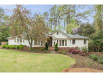 Charming home exterior with manicured lawn and blooming tree providing curb appeal at 3038 Nancy Creek Nw Rd, Atlanta, GA 30327