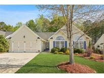 Charming home featuring a well-manicured lawn, a two-car garage, and large windows with blue shutters at 205 E Skyline Vw, Dallas, GA 30157