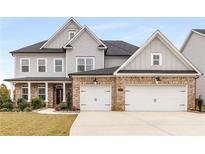 Beautiful two-story home features a brick and gray color scheme, two-car garage, and manicured lawn at 501 Blackberry Ln, Canton, GA 30115
