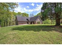 Charming brick home with a well-manicured lawn and mature trees, perfect for enjoying the outdoors at 5894 Highway 20 Ne, Cartersville, GA 30121