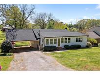 Charming single-story home with a covered carport and well-maintained front lawn at 313 Ellenwood Dr, Bowdon, GA 30108