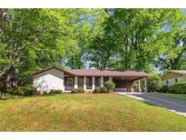 Charming one-story home with white brick, covered parking, and a lush green lawn at 3944 Woburn Dr, Tucker, GA 30084