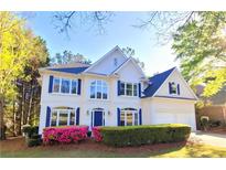 Charming two-story traditional home with a manicured lawn and flowering shrubs at 505 Tilbury Dr, Suwanee, GA 30024