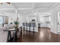 Open-concept living area with hardwood floors flowing into the kitchen with white cabinets and breakfast bar seating at 725 Mcwilliams Se Rd, Atlanta, GA 30315