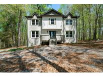 Charming two-story home with painted brick, dormers, and welcoming front porch at 7771 A C Smith Rd, Cumming, GA 30028