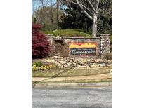 Stone sign for The Villas at Gingercake community with colorful landscaping and stone wall at 220 Rehobeth Way, Fayetteville, GA 30214