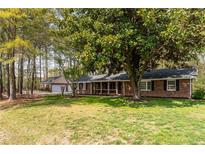 Charming brick home with a well-manicured lawn and mature trees at 4220 Smith Rd, Loganville, GA 30052