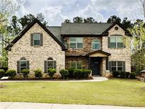 Inviting two-story home with brick and stone facade, set on a well-manicured lawn with mature trees at 5617 Casa Blanca Ln, Atlanta, GA 30331
