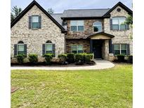 Charming two-story brick home with manicured lawn and complemented by professionally installed landscaping at 5617 Casa Blanca Ln, Atlanta, GA 30331