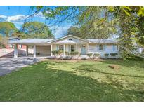 Charming single-story home featuring a brick facade, light blue shutters, and a well-manicured front lawn at 1830 Mayfield Rd, Alpharetta, GA 30009