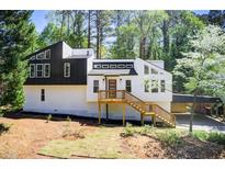 Modern two-story home with black and white accents, wooden deck, and a convenient carport at 4544 Savage Ne Dr, Marietta, GA 30066