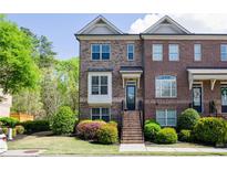 Charming brick townhome featuring a landscaped front yard and inviting entryway steps at 1026 Township Sq, Alpharetta, GA 30022