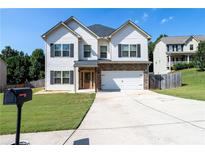 Charming two-story home featuring a well-maintained front yard, driveway, and inviting front door with stone accents at 309 Daffodil Dr, Temple, GA 30179