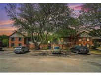 Apartment building with brick facade, mature trees and ample parking in front at 3105 Colonial Way # F, Atlanta, GA 30341