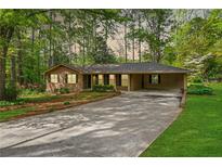 Charming single-story brick home with a long driveway, carport, and beautifully landscaped front yard at 1061 Pathfinder Rd, Marietta, GA 30066
