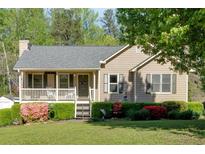 Charming single-story home featuring a cozy front porch, well-maintained lawn, and colorful landscaping at 198 Wiley Dr, Douglasville, GA 30134