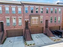 Brick townhome featuring attached garages, steps to the front door, and well-maintained landscaping at 2482 Crescent Park Ct, Atlanta, GA 30339