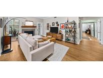 Bright living room with hardwood floors, fireplace, and comfortable sofa at 5105 Chemin De Vie, Atlanta, GA 30342