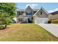 Charming two-story home with a two-car garage and well-maintained front lawn at 7431 St David St, Fairburn, GA 30213
