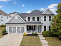 Charming two-story home with a well-manicured lawn, a two-car garage, and a welcoming front porch at 924 Woodbury Rd, Canton, GA 30114