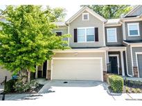 Charming townhome featuring an attached garage, neutral colors, and a beautiful landscaped yard with flowering plants at 1058 Mays Sw Hl, Atlanta, GA 30336