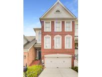 Charming brick townhome with a two-car garage and well-maintained landscaping at 195 Mystic Ct, Atlanta, GA 30342