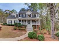 Charming two-story home with a welcoming front porch and beautifully landscaped front yard at 657 Swans Landing Dr, Dacula, GA 30019