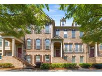 Charming brick townhome featuring a welcoming front porch and well-maintained landscaping, perfect for curb appeal at 1012 E Paces Chase, Atlanta, GA 30326