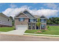Charming two-story home with a brick and siding exterior, complemented by a well-manicured lawn and a two-car garage at 1054 Georgian Point Dr, Lawrenceville, GA 30045