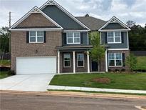 Two-story home featuring a brick and siding facade, attached garage, and freshly laid lawn at 1054 Georgian Point Dr, Lawrenceville, GA 30045