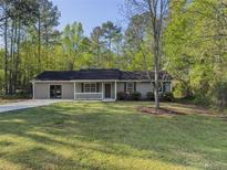 Charming single story home featuring a well manicured front yard and front porch at 175 Stoneview Cir, Covington, GA 30016