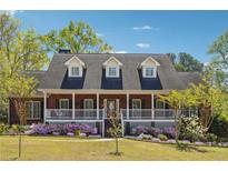 Beautiful brick home with a welcoming front porch and colorful flower beds at 255 Helens Manor Dr, Lawrenceville, GA 30045