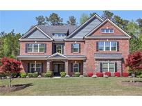 Traditional brick two-story home featuring manicured lawn, trees, black shutters, and well-maintained landscaping at 1622 Bunting Forest Ct, Marietta, GA 30064